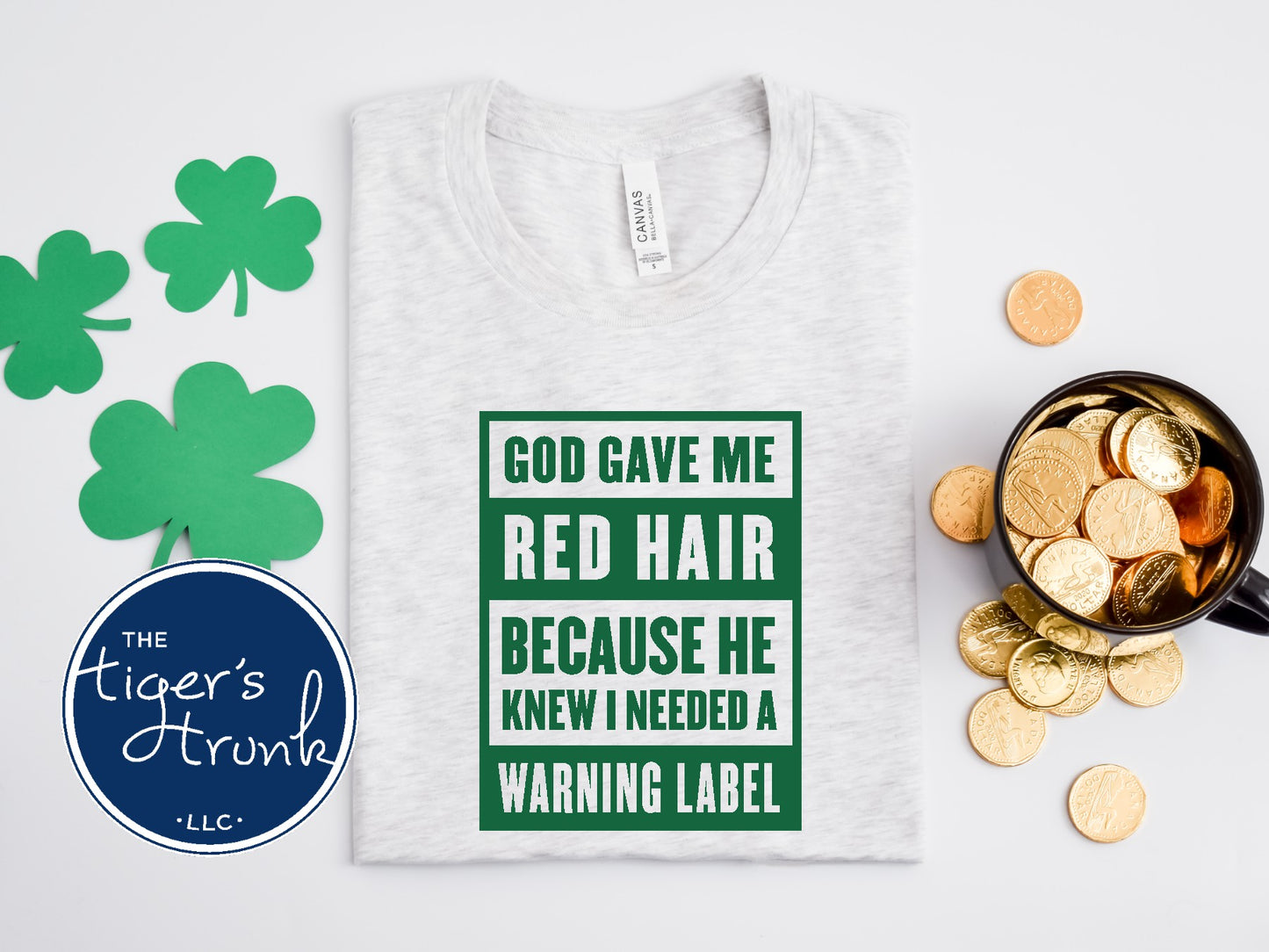 St. Patrick’s Day red hair warning label shirt in heather ash with shamrock decorations.