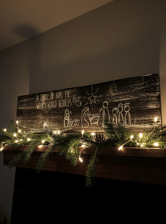 rustic black nativity wooden sign displayed with Christmas garland and lights