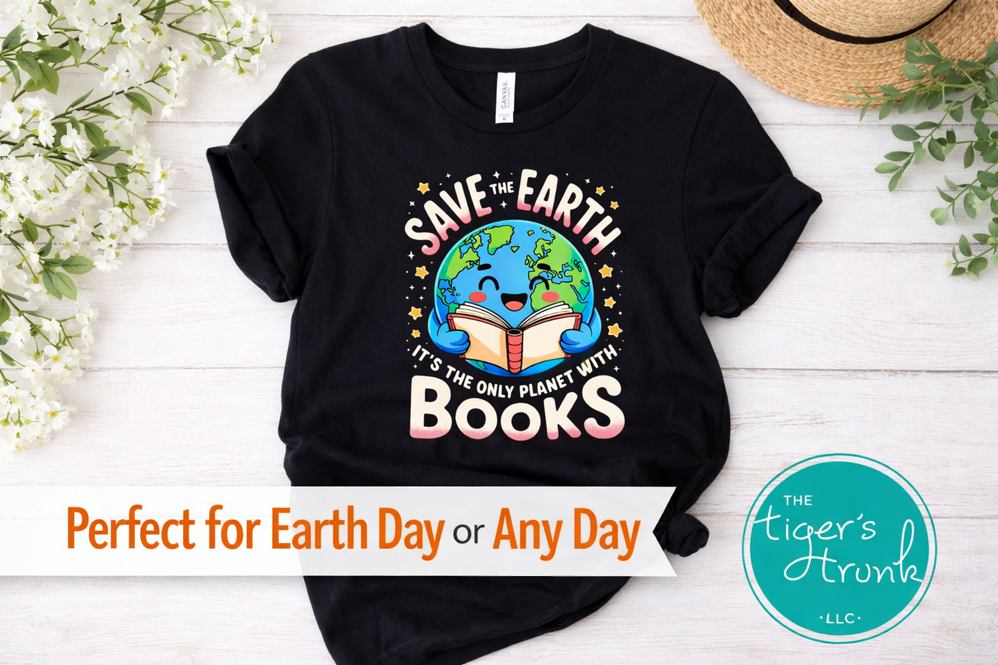 Black t-shirt with 'Save the Earth, It's the Only Planet with Books' design on a white wooden surface with flowers and a hat.