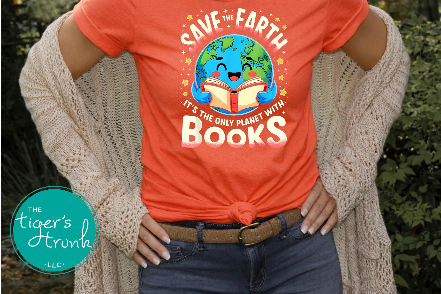 Person wearing an orange t-shirt with a graphic and text 'Save the Earth, it's the only planet with books'.