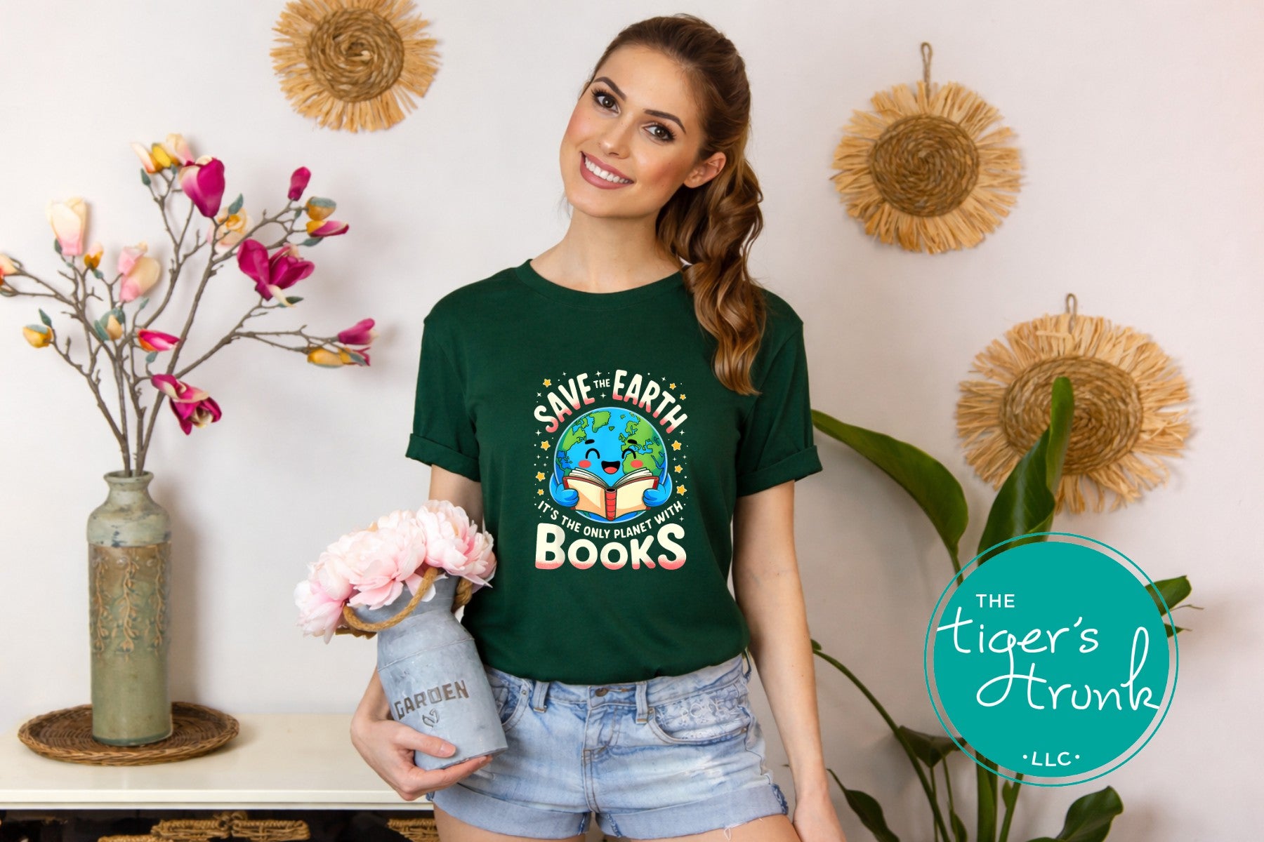 Woman wearing a green t-shirt with a 'Save Earth, Start with Books' design, holding flowers, in a home setting.
