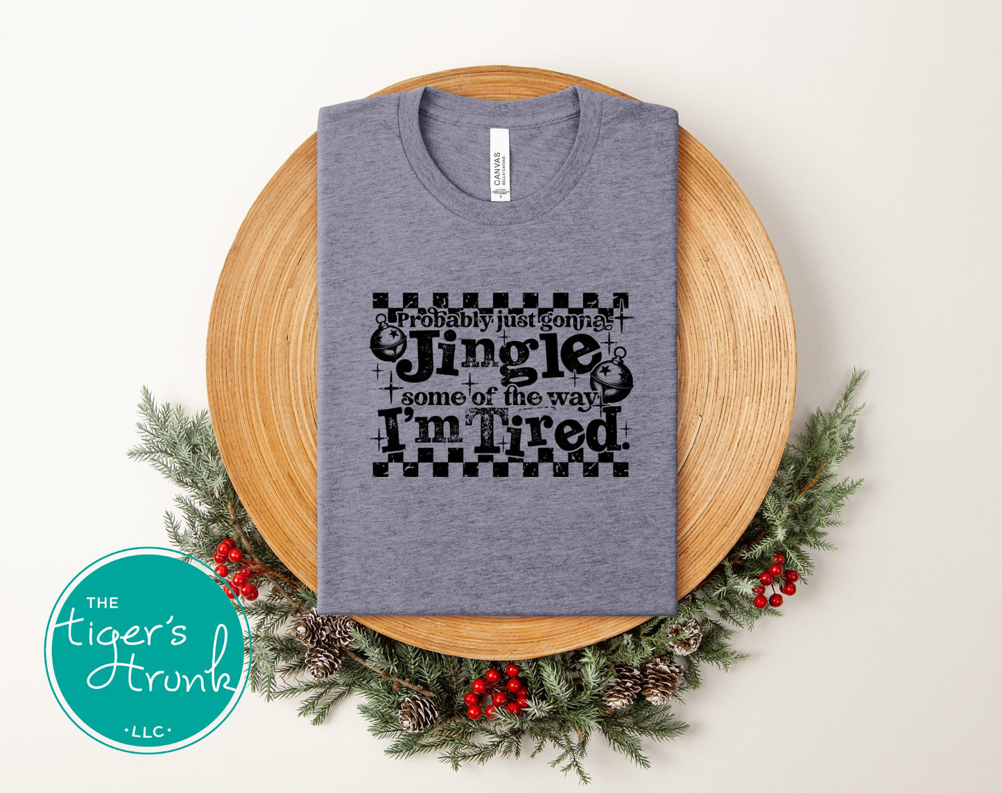 Gray t-shirt with Christmas-themed text on a wooden plate with decorative elements