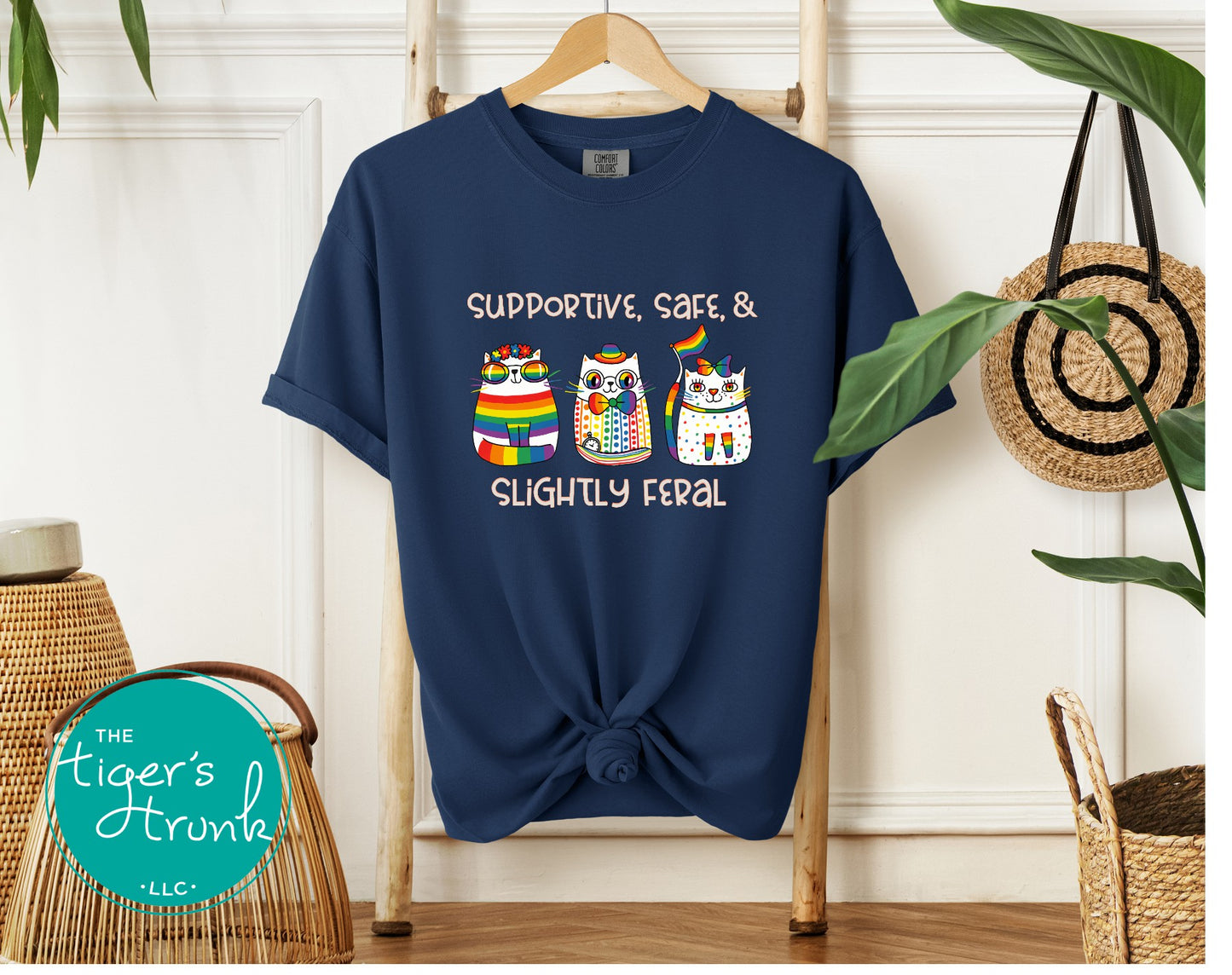 Navy blue t-shirt with colorful owl design and text on a hanger against a white wall.