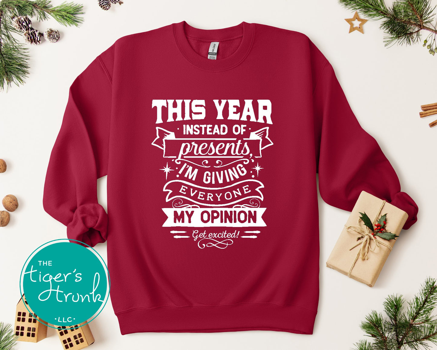 Red sweatshirt with white text on a white background with Christmas decorations.