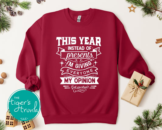 Red sweatshirt with white text on a white background with Christmas decorations.