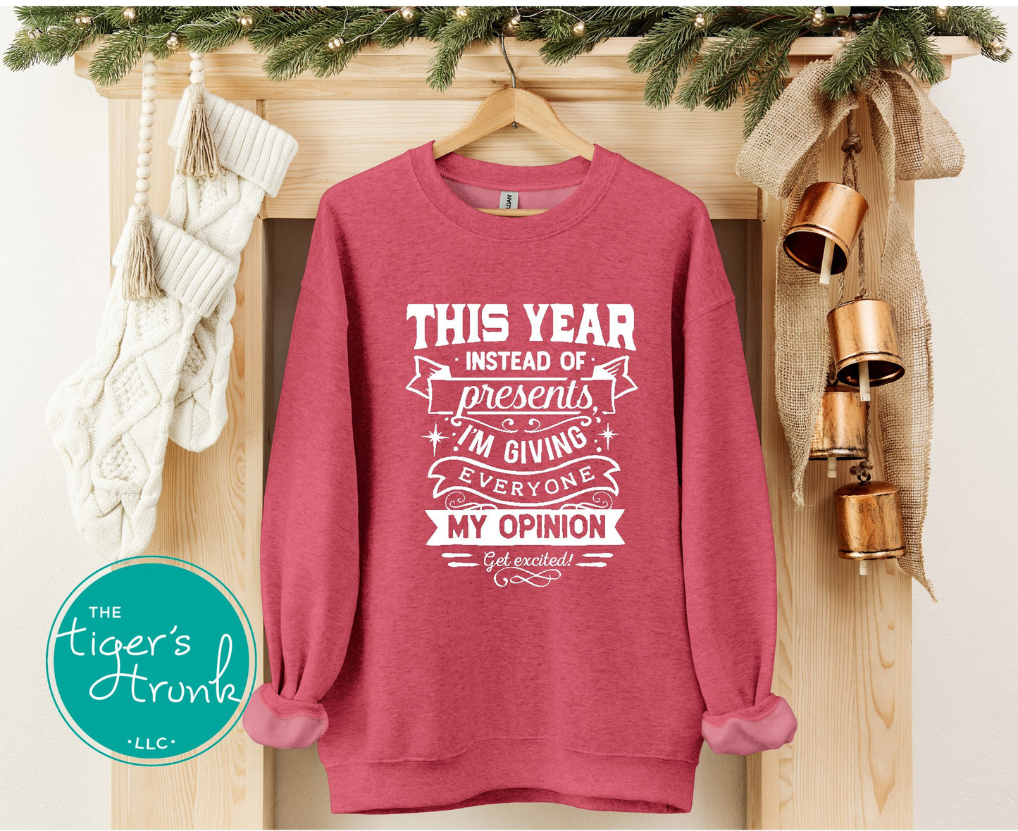 Pink sweatshirt with humorous text design on a wooden surface with decorative elements.