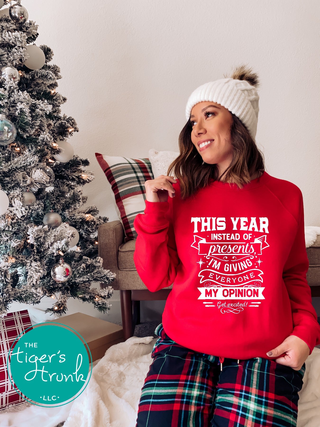 Woman wearing a red sweater with text in a festive living room.