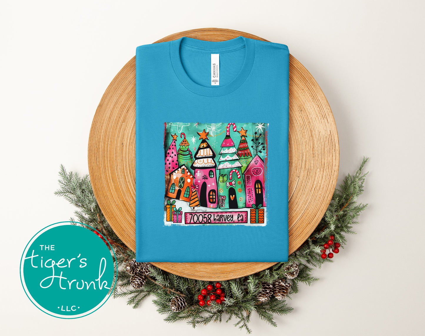 Aqua Christmas shirt with bright illustrated holiday houses and trees personalized with ZIP code 70058 Harvey, LA.