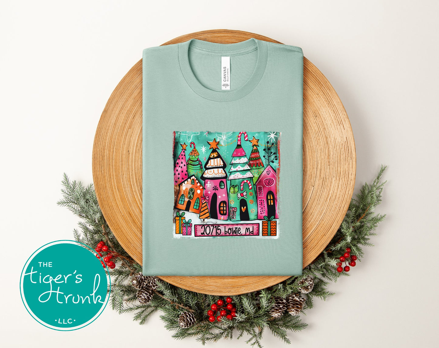 Dusty blue Christmas shirt decorated with colorful festive houses and trees including ZIP code 20715 Bowie, MD.”