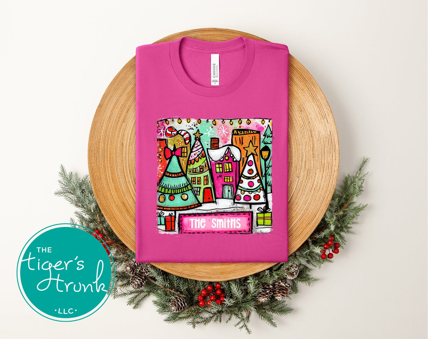 Pink t-shirt with a colorful graphic and 'The Smiths' text on a wooden board with Christmas decorations.