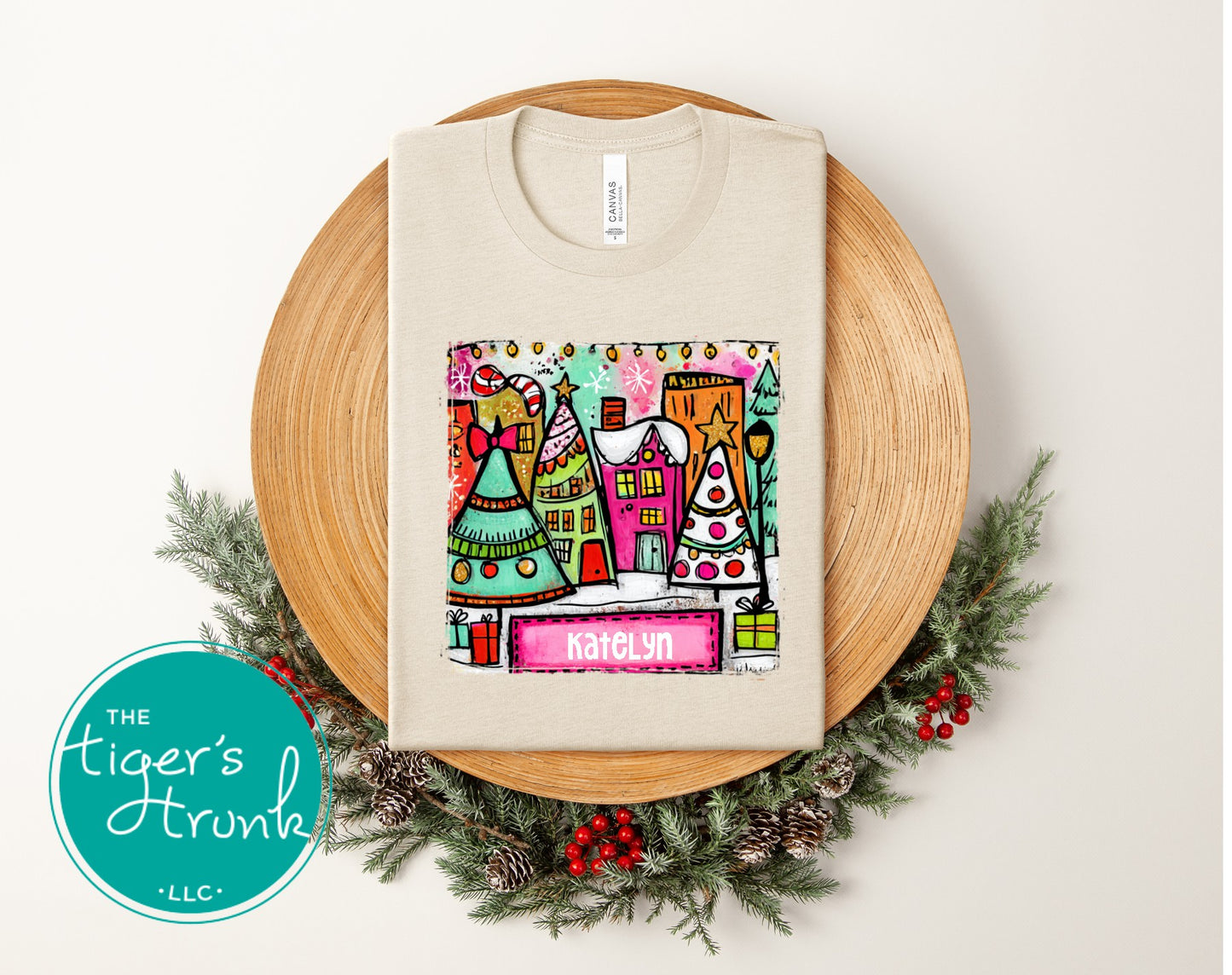 Beige t-shirt with colorful graphic design on a wooden board with Christmas decorations