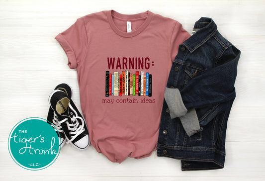 Graphic t-shirt featuring banned books and the phrase "Warning: May Contain Ideas," ideal for librarians, educators, and book lovers