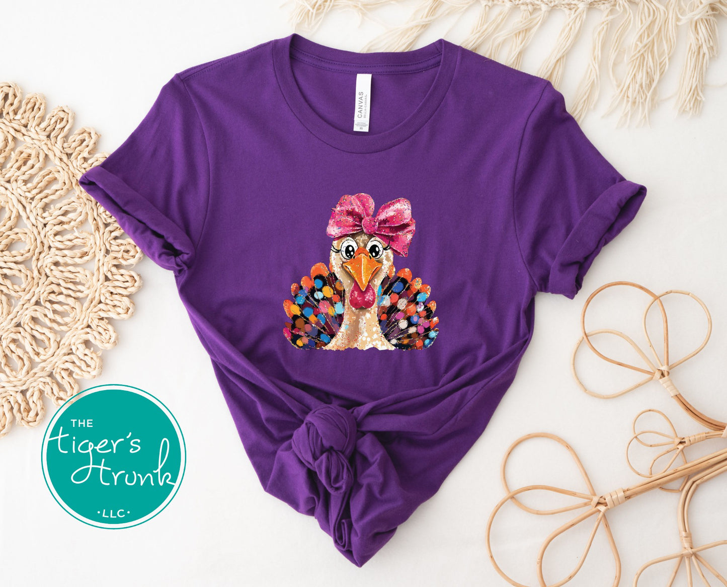 Purple t-shirt with a colorful turkey design and bow, on a white background with decorative elements.