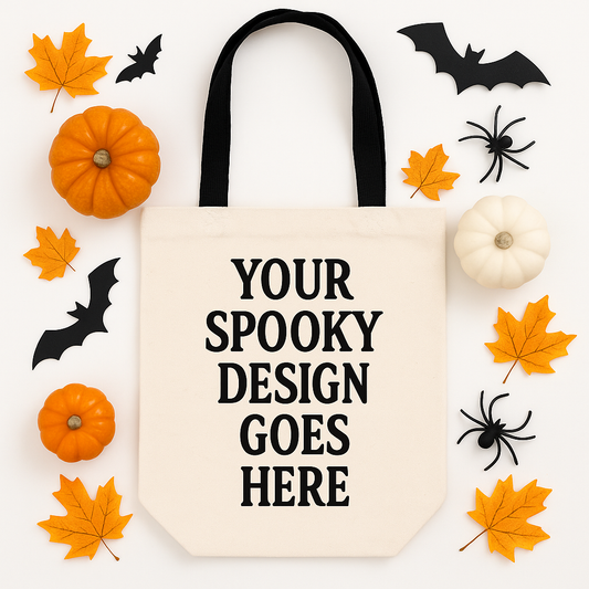 Blank tote bag with 'Your Spooky Design Goes Here' text, surrounded by Halloween decorations on a white background.