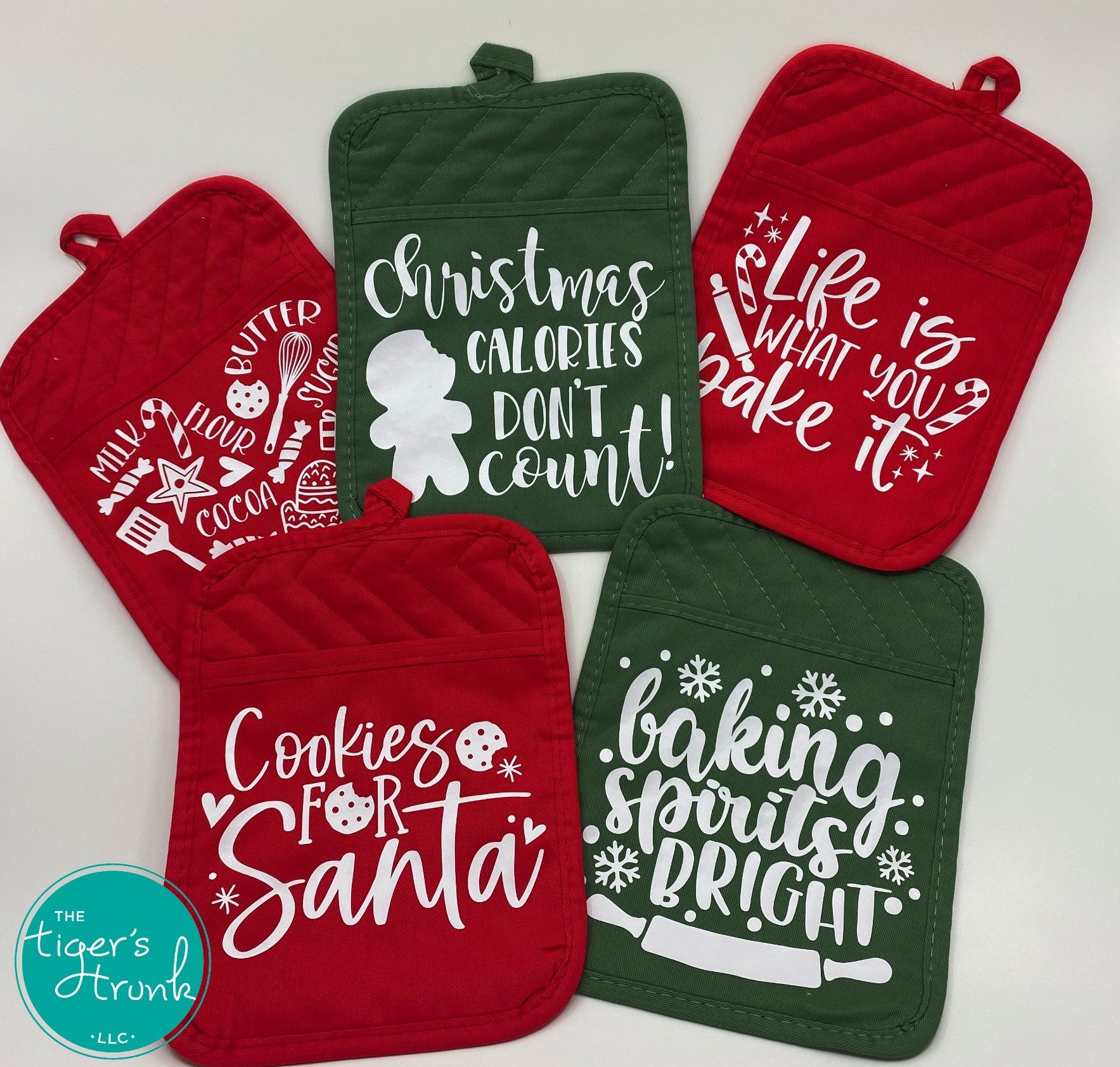 Red and green Christmas pot holders with holiday sayings arranged together on a white background