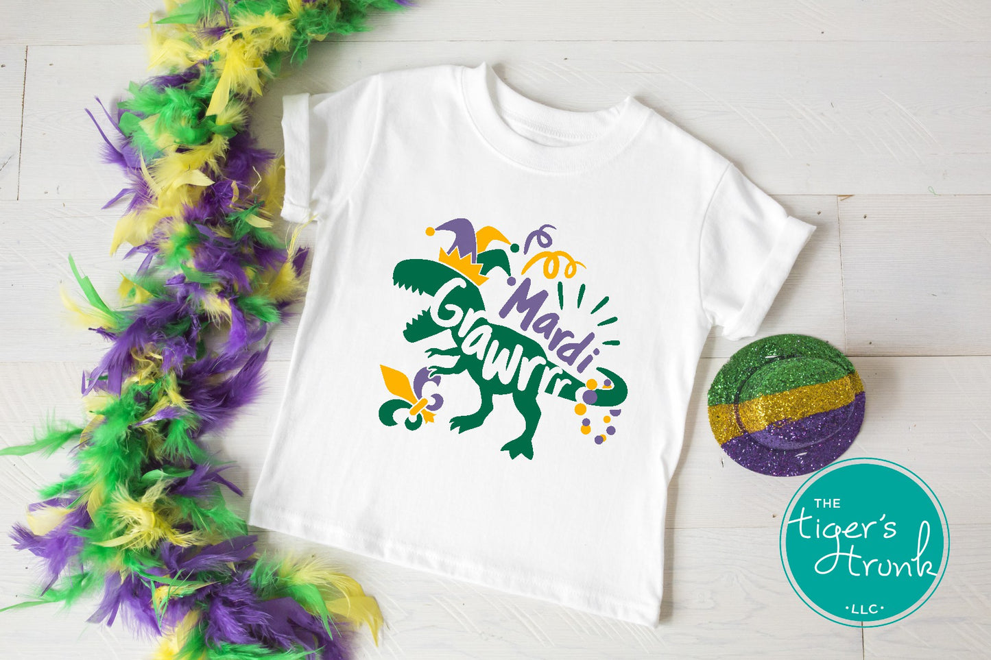 Kids Mardi Gras t-shirt featuring a playful dinosaur design with the phrase Mardi Grawrr, perfect for parades and celebrations.