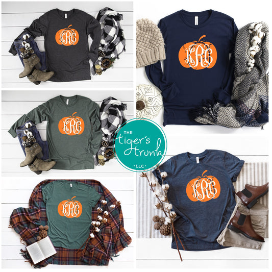 A collage of four images featuring a fall-themed shirt with a pumpkin-shaped monogram, available in both green and navy colors. The shirt is presented in different styles, some with long sleeves and others with short sleeves, all laid out with accessories and a book in the background.